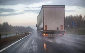 Large Commercial Truck Driving On A Wet Highway During Rainy Weather, Representing The Types Of Cases Handled By An Irving Truck Accident Lawyer.