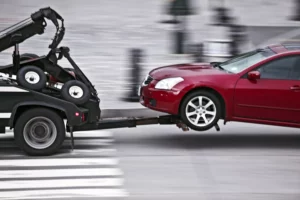 A Red Car Being Towed By A Tow Truck In Dallas, Representing A Situation Where A Dallas Tow Truck Accident Lawyer May Be Needed.