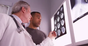 Doctor Showing A Patient Brain Scan Images While Discussing A Possible Concussion Diagnosis.