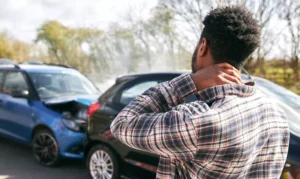 Man Holding His Neck After A Car Accident Involving Two Vehicles, Illustrating The Type Of Situation That A Cockrell Hill Personal Injury Lawyer Can Assist With.
