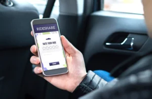A Person Holding A Smartphone With A Rideshare Rating Screen Displayed While Seated In A Vehicle, Representing The Need For A Desoto Rideshare Accident Lawyer.