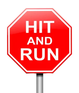 Red Octagonal Sign With Bold White Text That Reads &Quot;Hit And Run,&Quot; Symbolizing The Concept Of A Hit-And-Run Incident, Representing The Question Does Insurance Cover A Hit And Run.