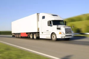 White 18-Wheeler Truck Driving On A Highway In Lancaster, Texas, Representing A Scenario Handled By A Lancaster Truck Accident Lawyer.