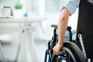 Dallas Catastrophic Injury Lawyer – Person In A Wheelchair At A Desk, Symbolizing Recovery And Legal Support After A Life-Altering Injury.