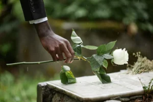 Duncanville Wrongful Death Lawyer Helping Families Honor A Loved One Lost Due To Negligence, With A White Rose Placed On A Gravestone In The Rain.