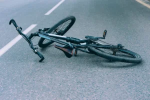 Damaged Bicycle Lying On The Road After A Crash, Representing The Aftermath Of An Accident Handled By A Grand Prairie Bike Accident Lawyer.