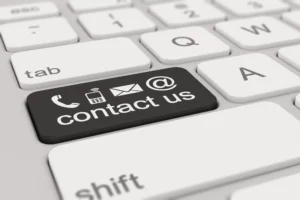 Contact Us Button On A Computer Keyboard, Featuring Phone, Email, And At-Symbol Icons, Emphasizing Multiple Ways To Reach Out.