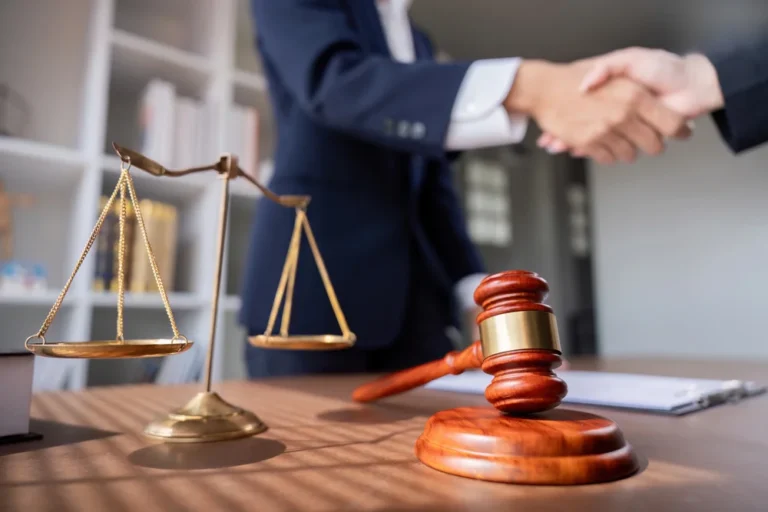 This image shows a client shaking hands with an attorney in an office setting, symbolizing the moment when to consult a lawyer for a truck accident becomes essential for protecting your legal rights.