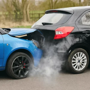 Two Cars With Visible Bumper Damage And Smoke After A Rear-End Collision On A Suburban Road, Illustrating A Case Handled By A Desoto Rear End Accident Lawyer.