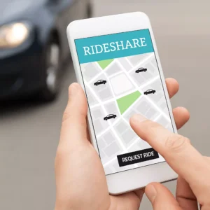 A Person Uses A Rideshare App On Their Phone Near A Parked Vehicle, Illustrating The Modern Transportation Context Handled By A Duncanville Rideshare Accident Lawyer.