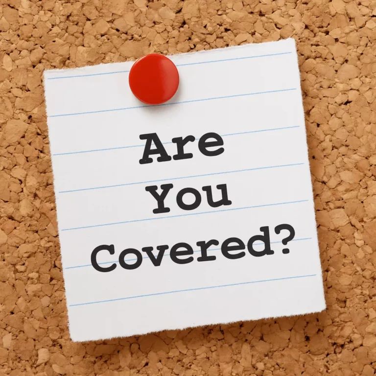A corkboard with a note pinned by a red pushpin reading “Are You Covered?” symbolizing the question of what does liability insurance cover.